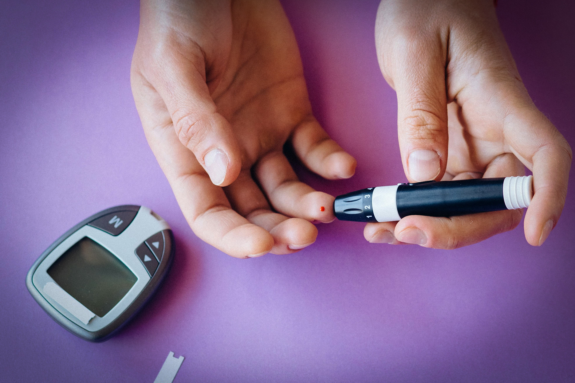 एक चिकित्सा उपकरण से रक्त शर्करा के स्तर को मापना।