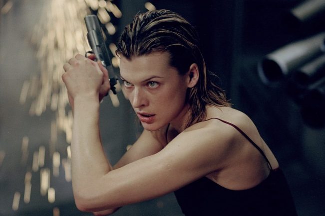 Milla Jovovich holds a gun and points it to the sky.
