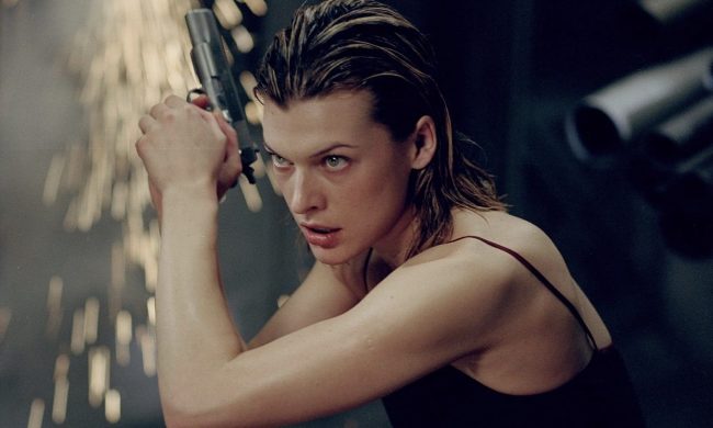 Milla Jovovich holds a gun and points it to the sky.