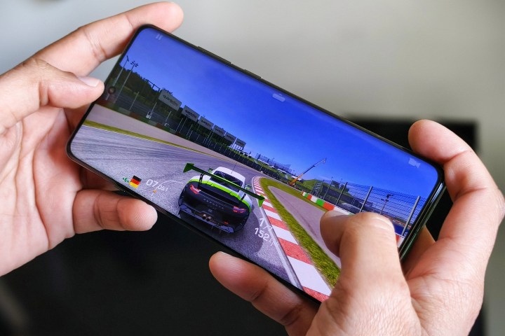 OnePlus 12 held in person's hand running Real Racing 3.