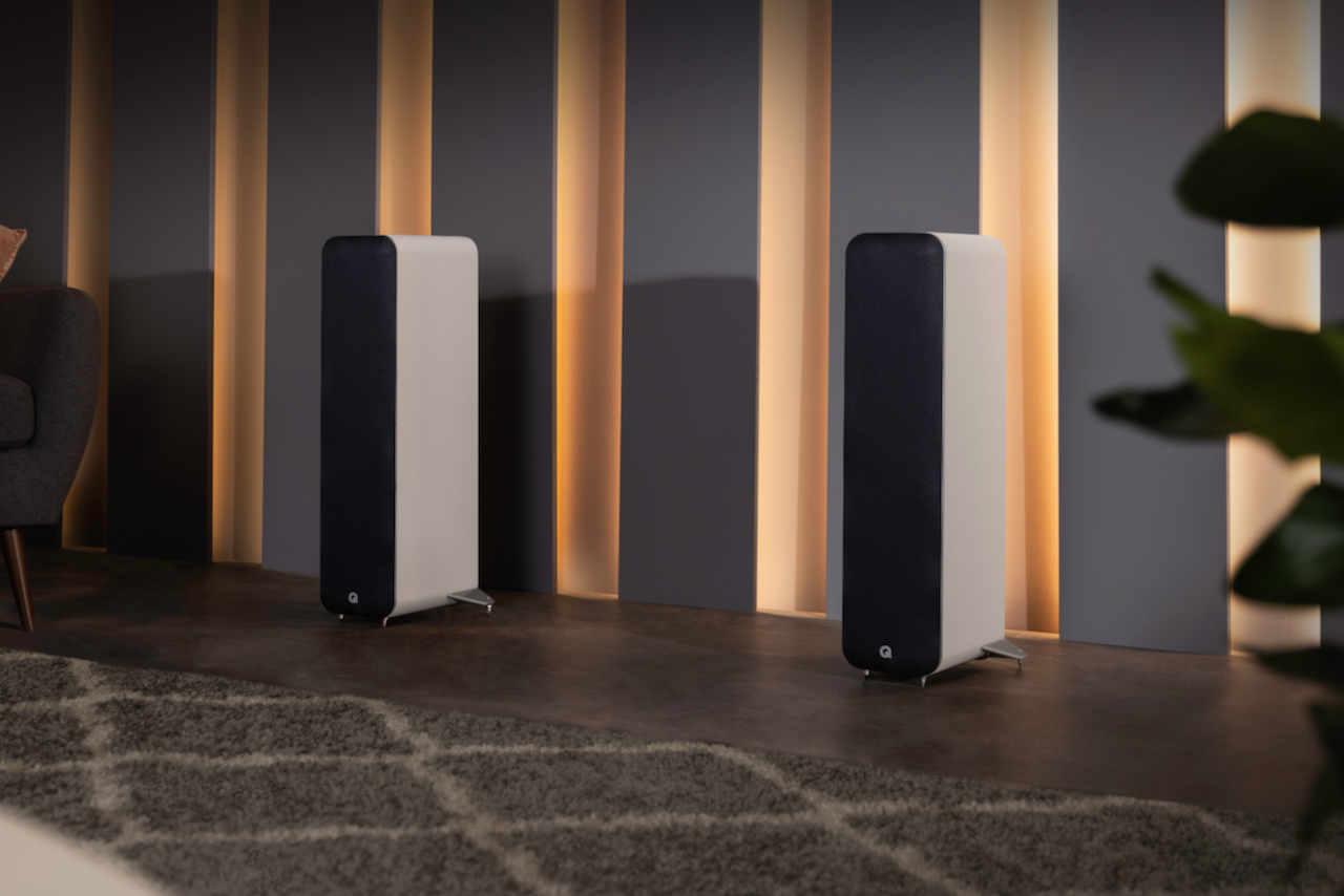 Two white Q Acoustics M40 powered micro-tower wireless audio system speakers.