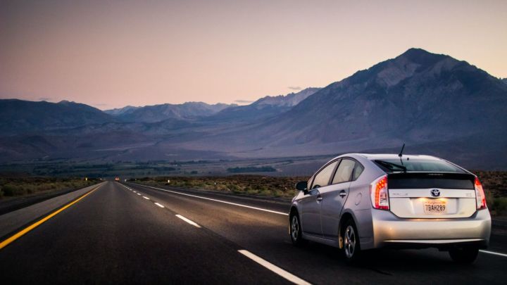 A Prius driving towards mountains.