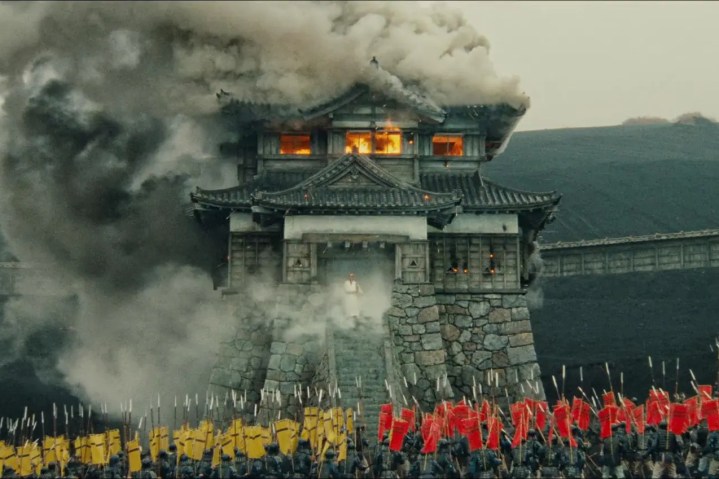 Ran'da yanan bir binanın önünde iki ordu duruyor.