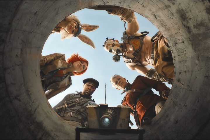 Five people stand at the top of a hole and look down.