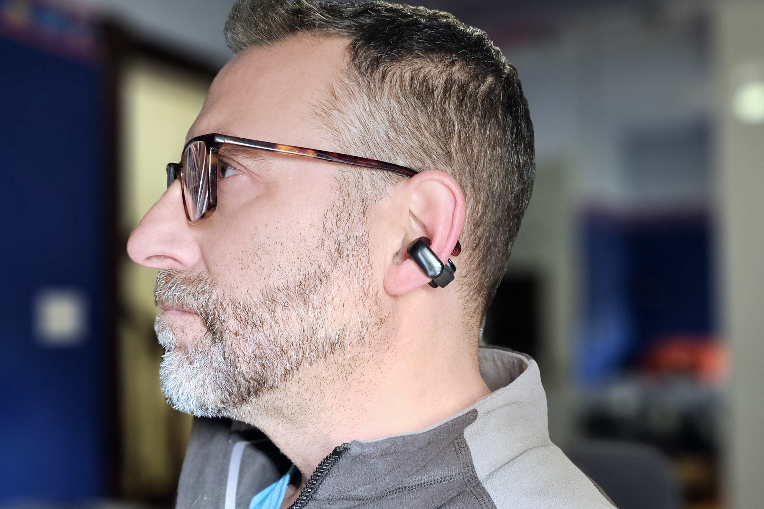Simon Cohen wearing the Bose Ultra Open Earbuds with glasses.