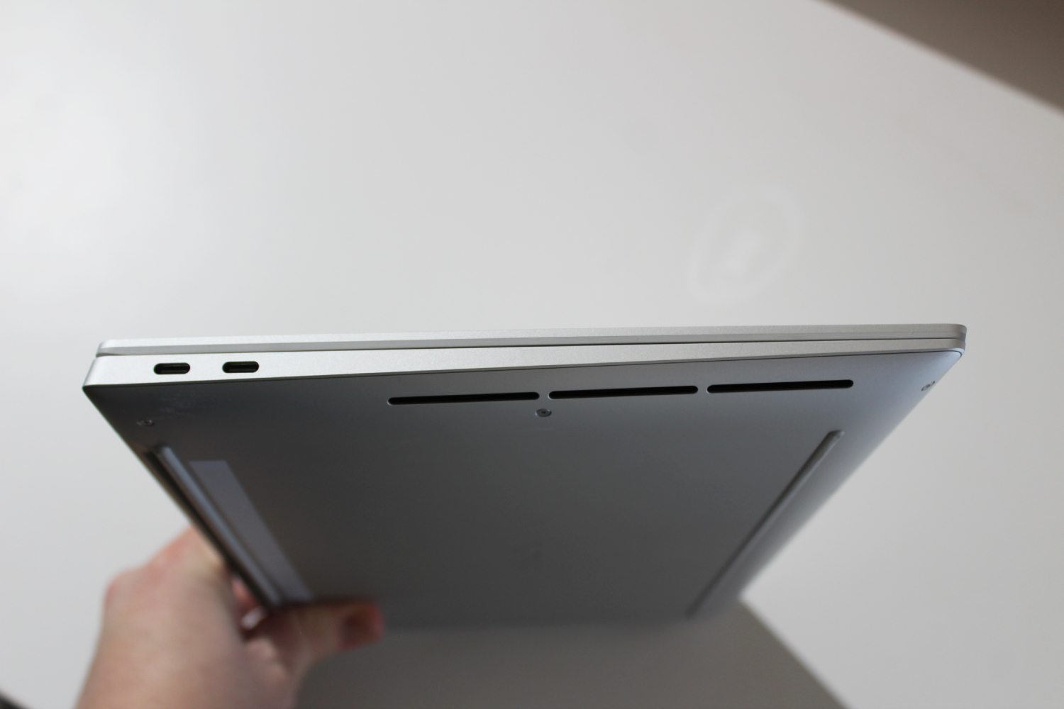 The side of the XPS 14, being held up by a hand.