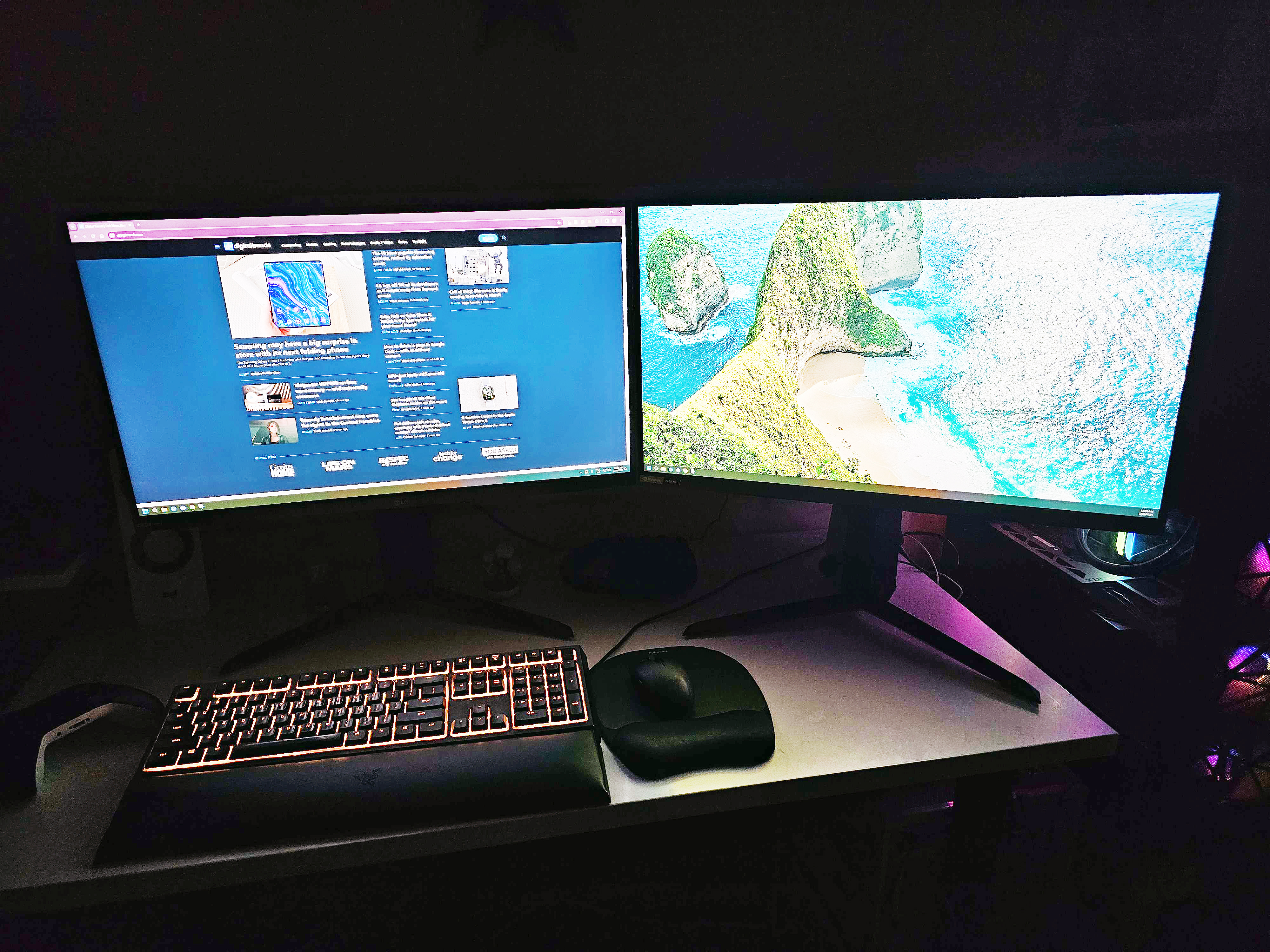 Two LG UltraGear monitors sit on a desk in front of a dark background.