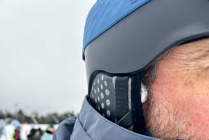 The H2O SnowPro skiing headphones peeking out from under a ski helmet.