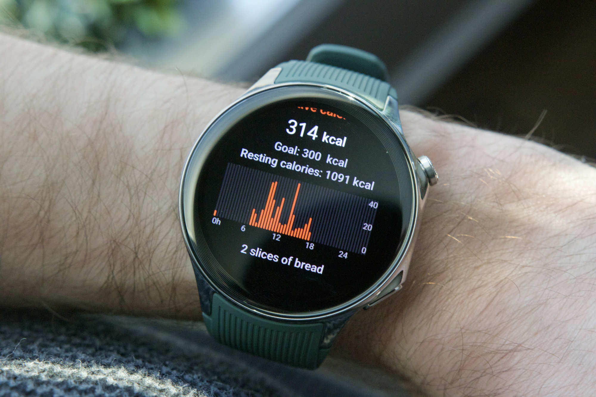 Someone wearing the OnePlus Watch 2, with the screen showing a graph of active calories burned.