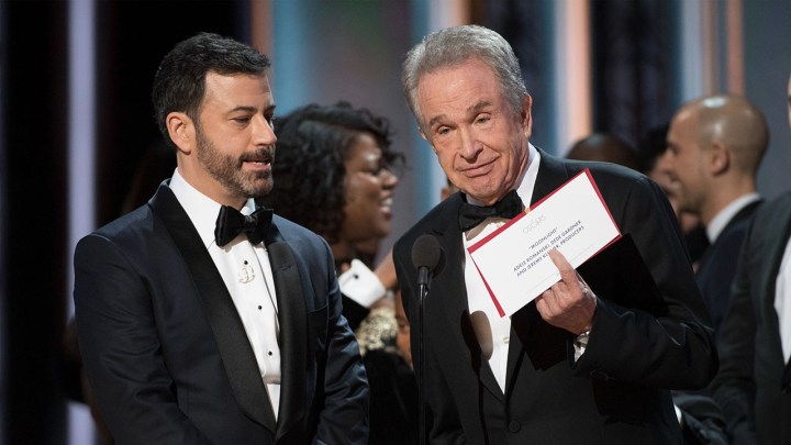 Warren Beatty holding the Academy Award Best Picture card to face the audience, Jimmy Kimmel standing beside him.