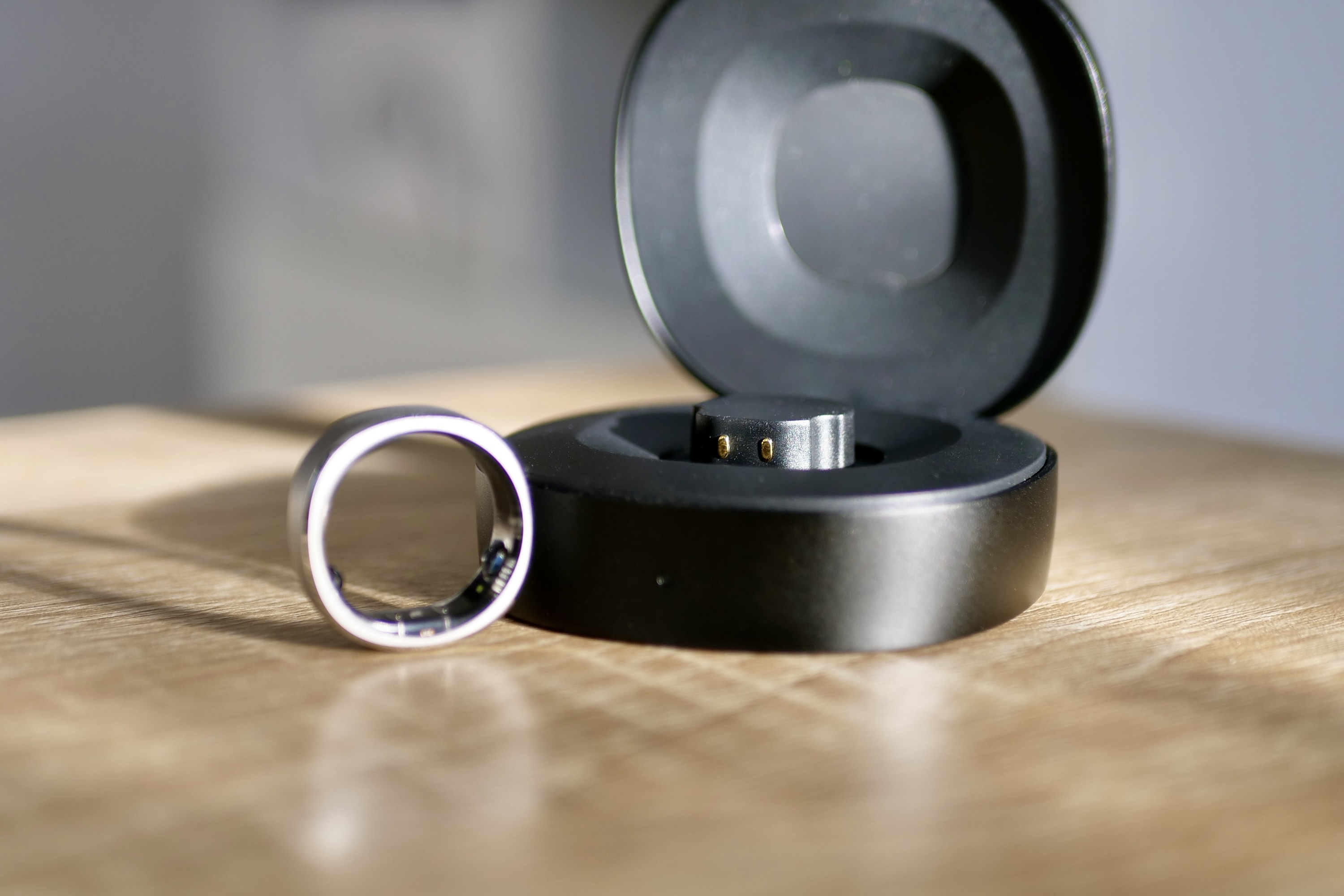 The RingConn Smart Ring next to the open travel charger case.
