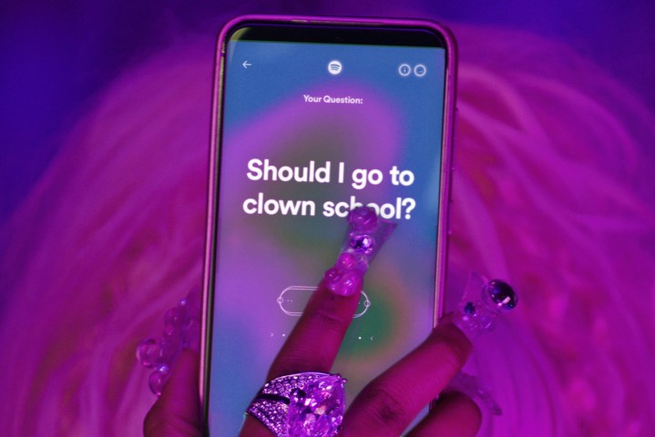 Una imagen de una mano en un teléfono inteligente que muestra la función Song Psychic de Spotify.