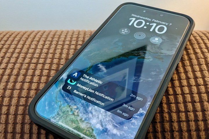 جهاز iPhone 15 Pro مع واقي شاشة وحافظة عليه.