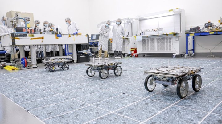 Como parte de la demostración de tecnología CADRE de la NASA, tres pequeños rovers que explorarán la Luna juntos muestran su capacidad para conducir en equipo de forma autónoma, sin órdenes explícitas de los ingenieros, durante una prueba en una sala limpia en el Laboratorio de Propulsión a Chorro de la agencia en diciembre de 2023. 