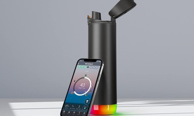 A Hidrate smart bottle with a smartphone leaning on it.