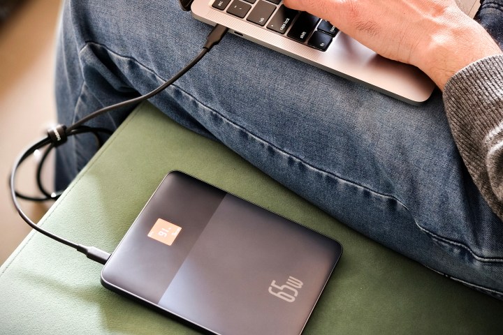 Baseus Blade 2 65W power bank for laptops kept on a green couch.