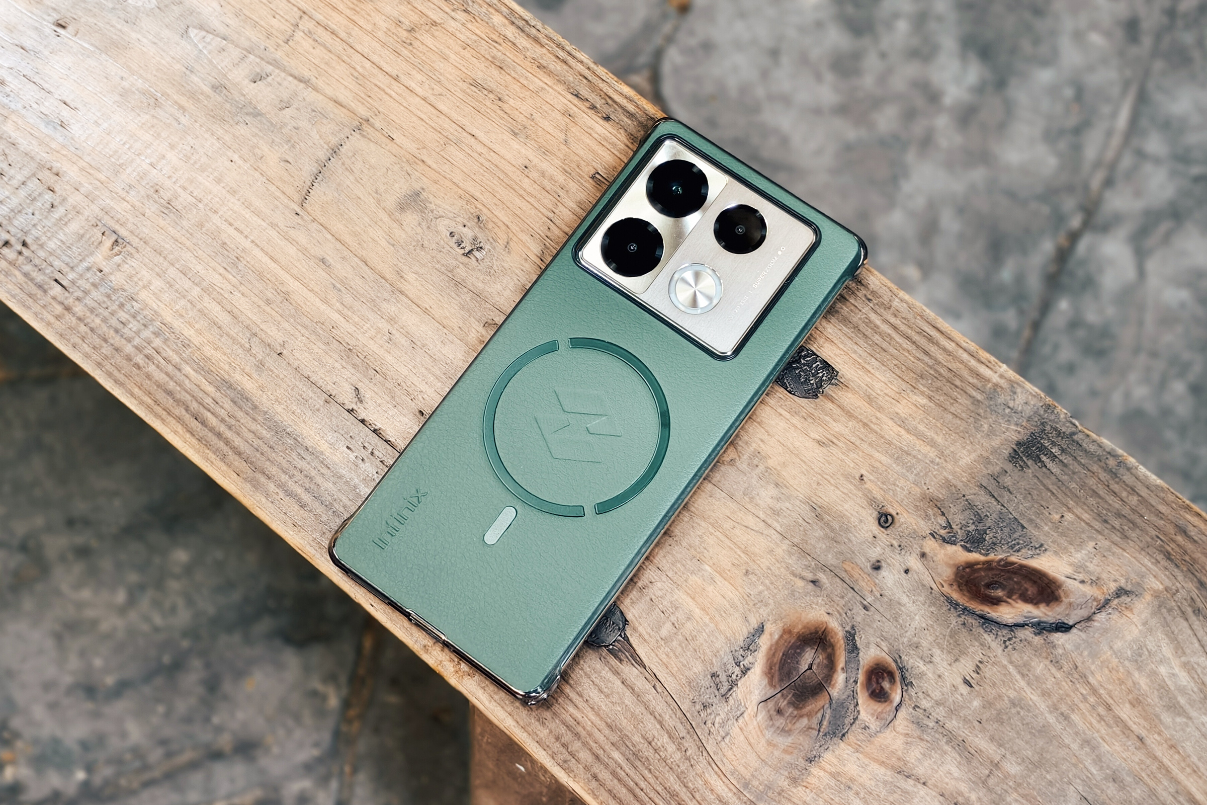 Infinix Note 40 Pro Plus con funda de cuero vegano compatible con MagSafe de color verde guardada sobre una mesa.