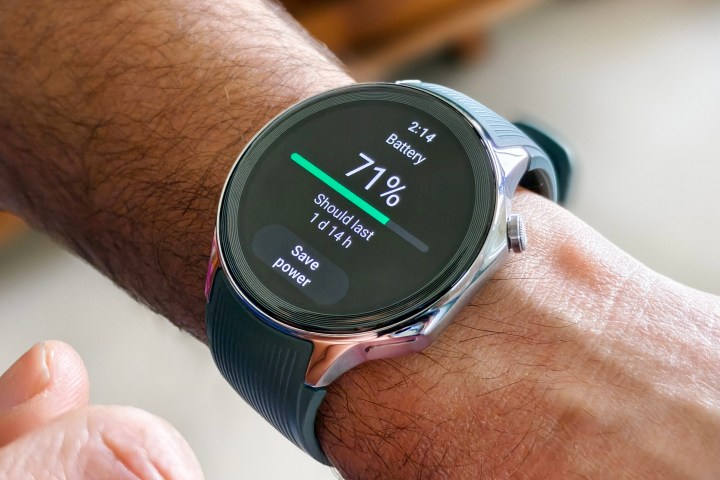 Persona que lleva OnePlus Watch 2 con una correa verde que muestra la duración restante de la batería.