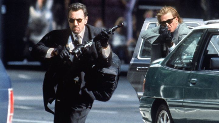 Robert De Niro and Val Kilmer as Neil McCauley and Chris Shiherlis aiming guns at something off-camera in Heat.