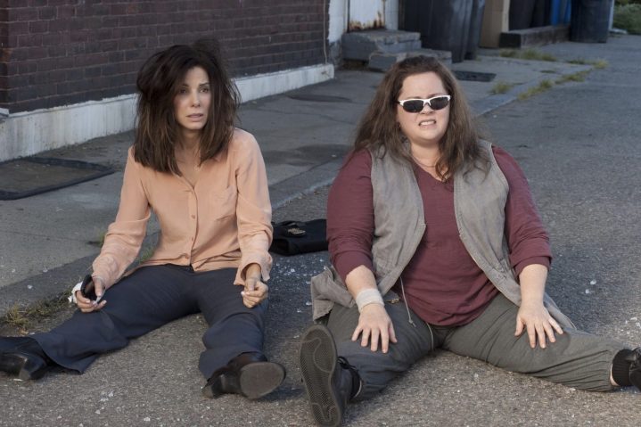 दो महिलाएँ जमीन पर एक दूसरे के बगल में बैठती हैं।