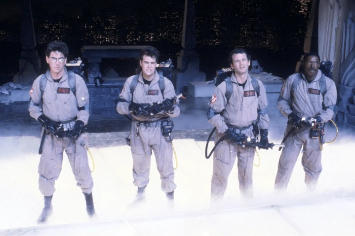 The original Ghostbusters stand on a rooftop together.