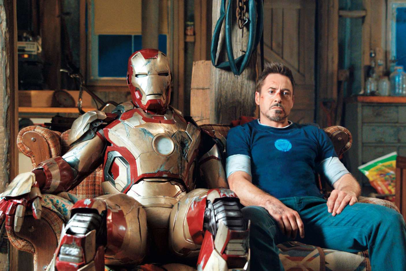Tony Stark sits next to his Iron Man suit in Iron Man 3.