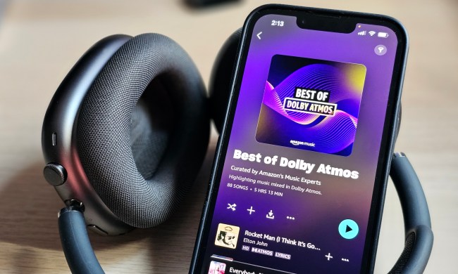 An iPhone 14 displaying the Amazon Music app with a Dolby Atmos Music playlist, next to a set of Apple AirPods Max headphones.
