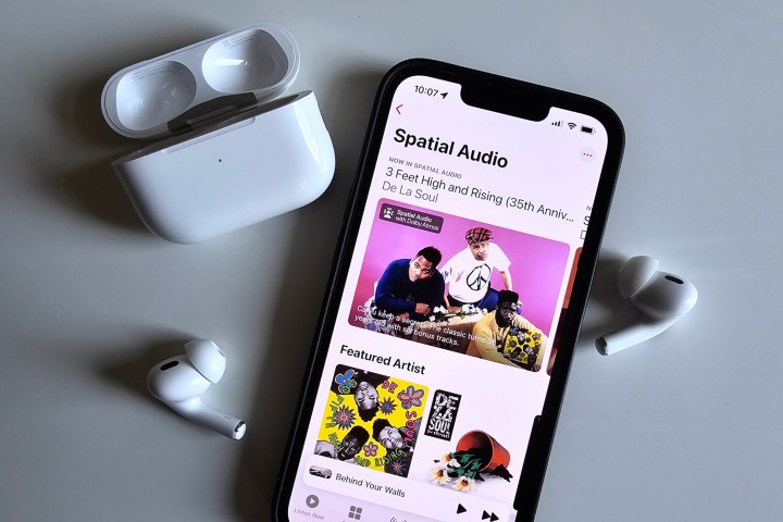 La colección de audio espacial de Apple Music vista en un iPhone 14, junto a los AirPods Pro de Apple.