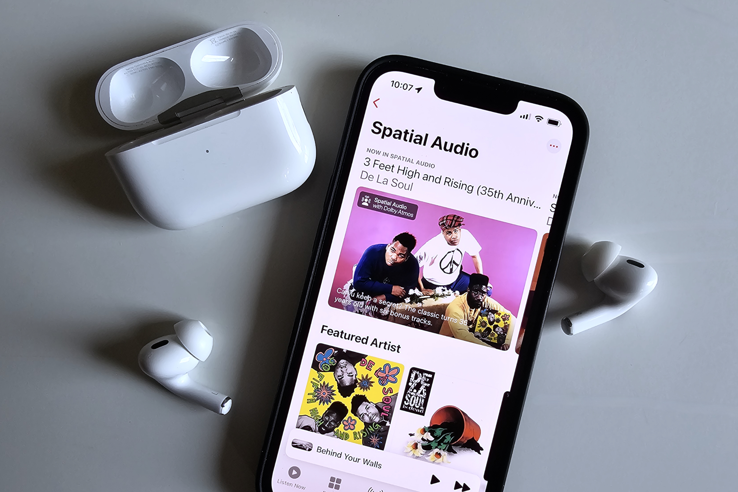 La colección de audio espacial de Apple Music vista en un iPhone 14, junto a los AirPods Pro de Apple.
