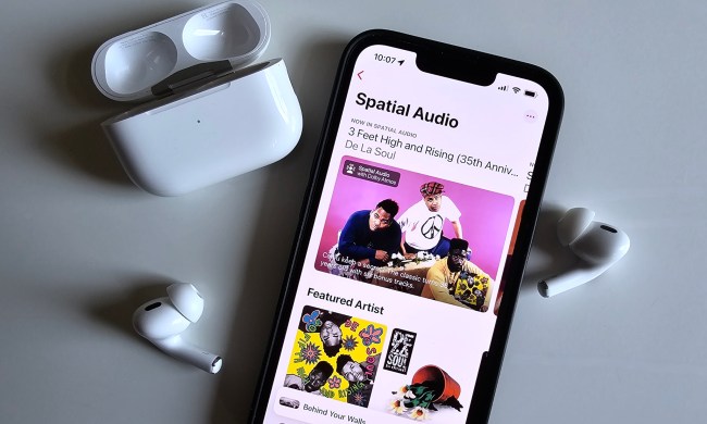 Apple Music's spatial audio collection seen on an iPhone 14, next to Apple AirPods Pro.