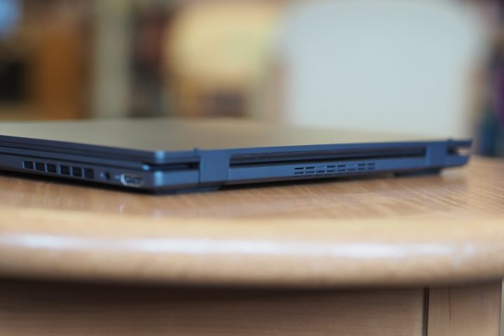 华硕 Zenbook DUO 2024 侧后视图，显示插入的键盘和通风口。