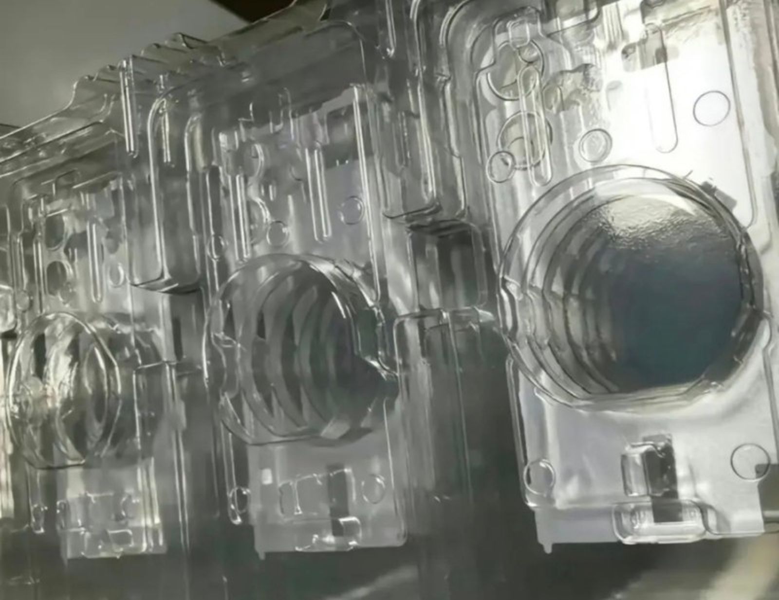 Molds of what appear to be the base model iPhone 16 showing a vertical camera layout.