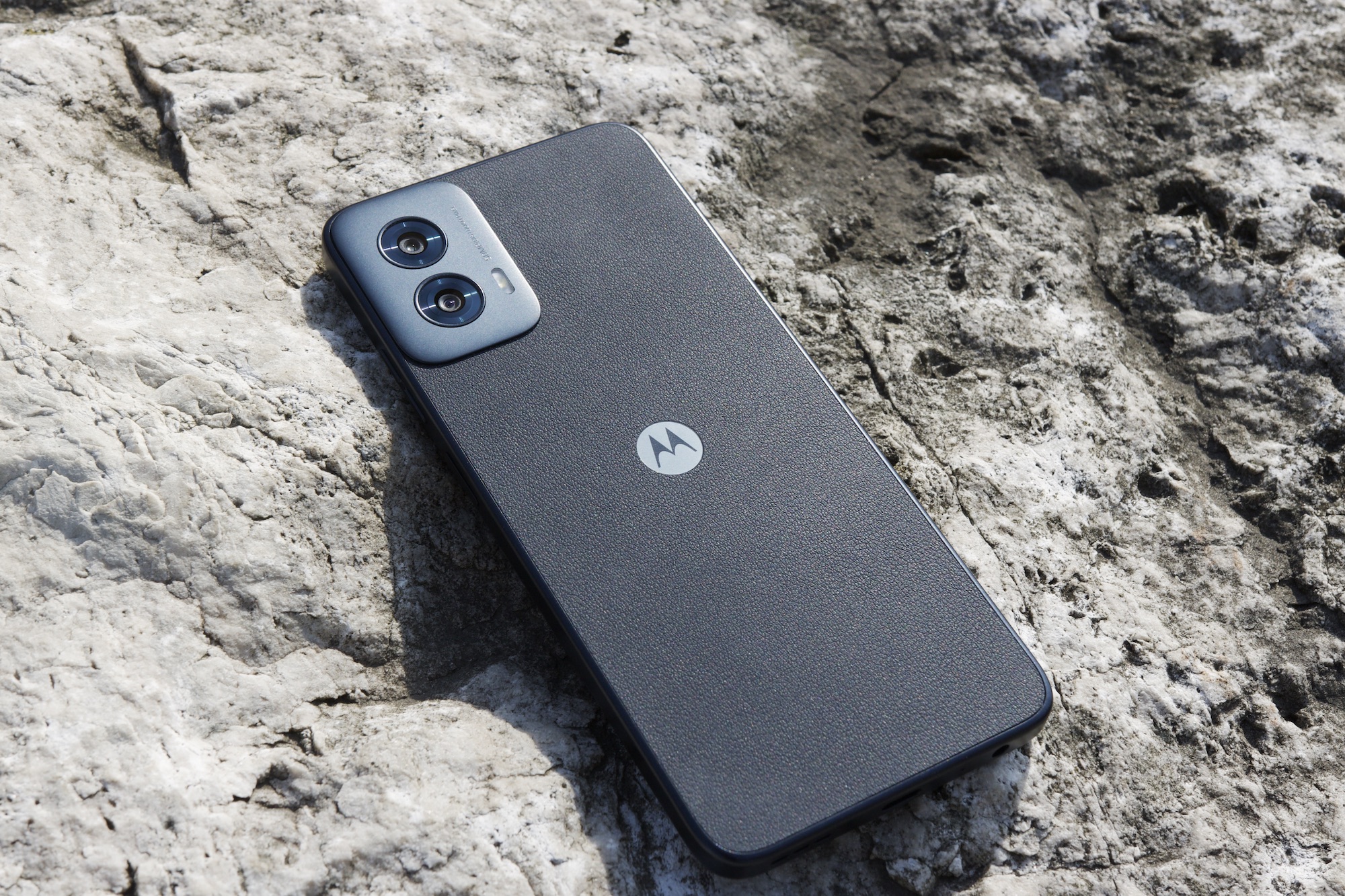 Moto G Power 5G (2024 г.) лежит на камне снаружи.