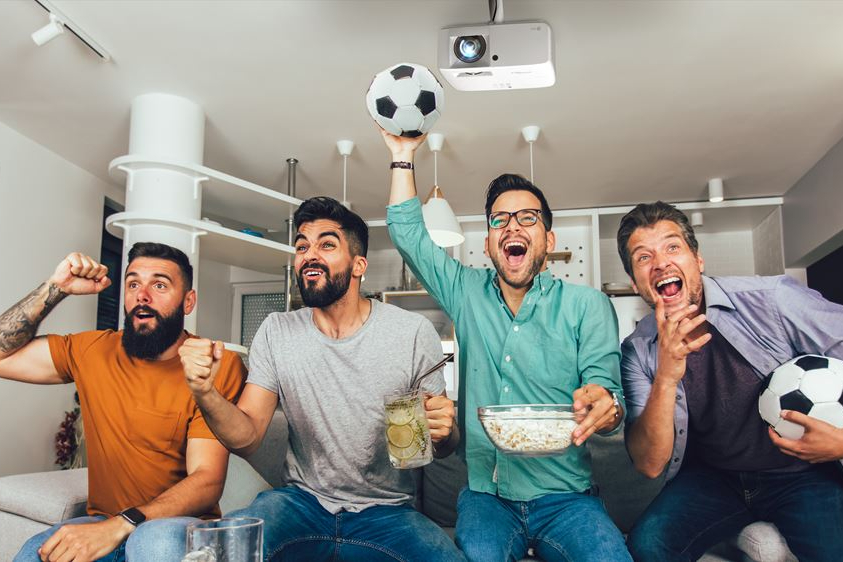 A group of men watching football with the Optoma GT2100HDR projector mounted on the ceiling.