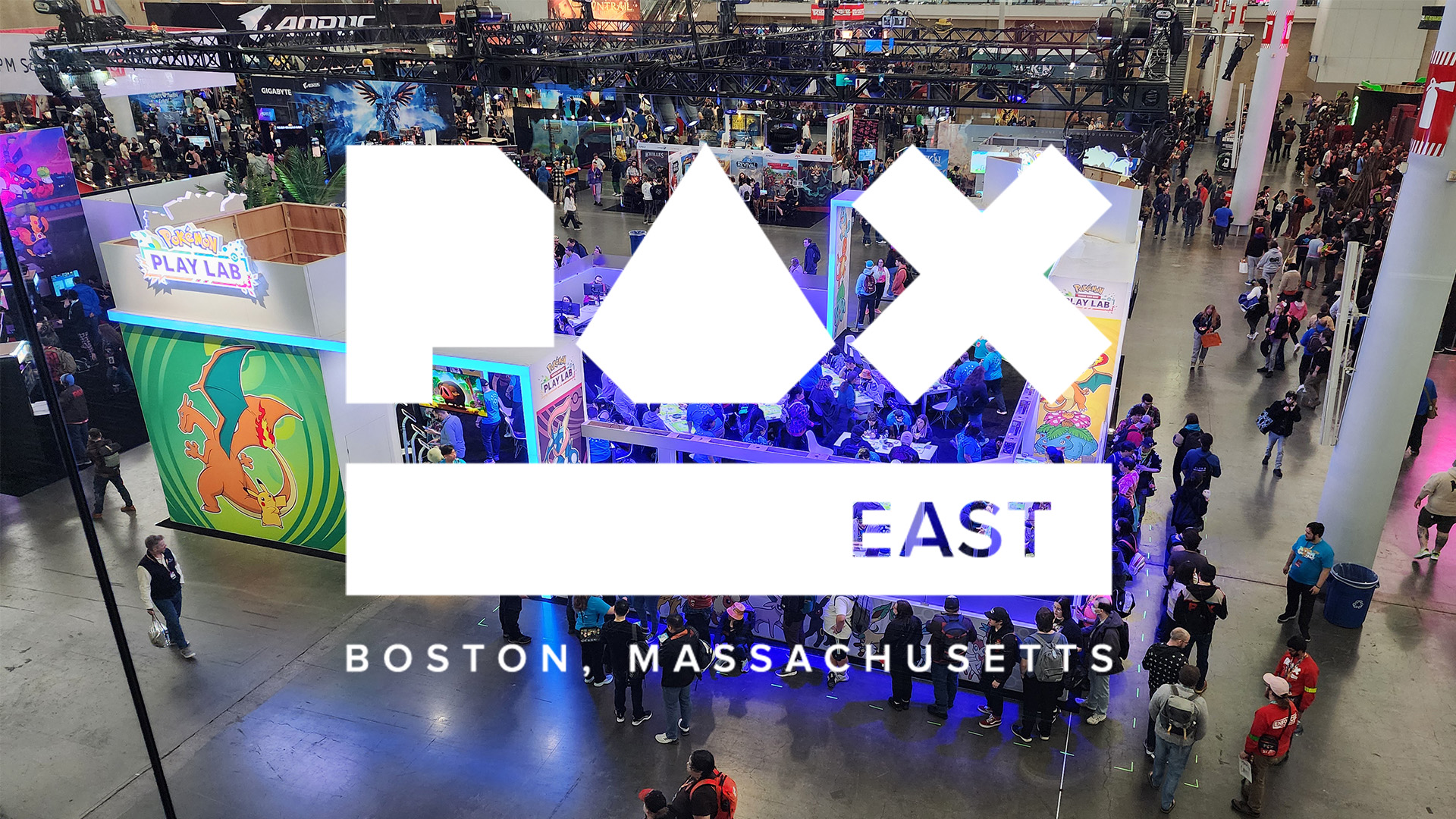 白色的 PAX East 标志位于繁忙的会议展厅图像上。