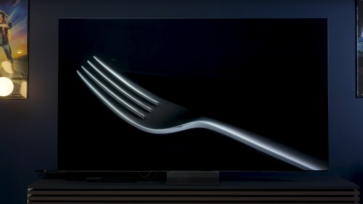 A closeup of a fork against a black background on a Samsung QN900D.