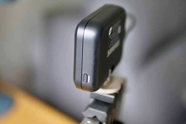 The power button on the side of the Shure MoveMic receiver.