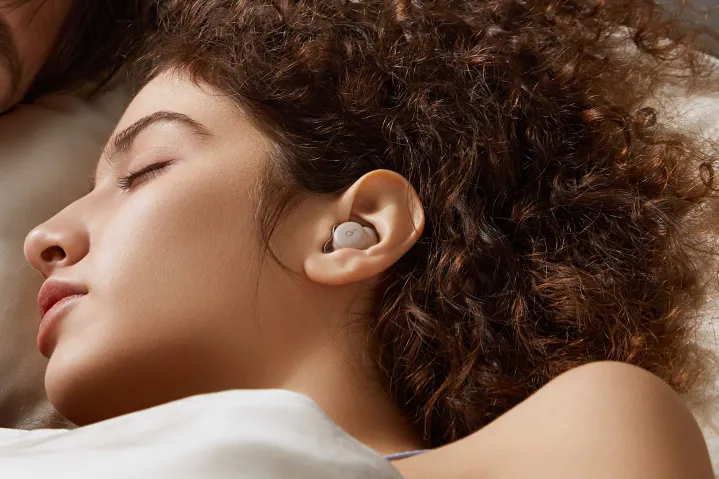 Woman wearing Soundcore Sleep A20 while side-sleeping.