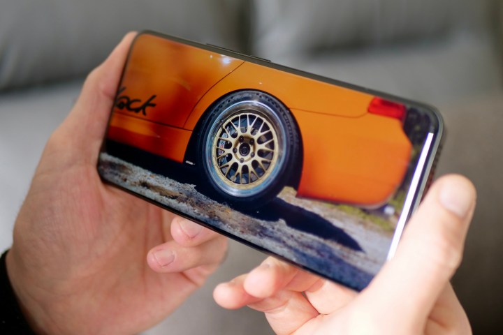 Xiaomi 14 Ultra को हाथ में लिए एक व्यक्ति वीडियो देख रहा है।