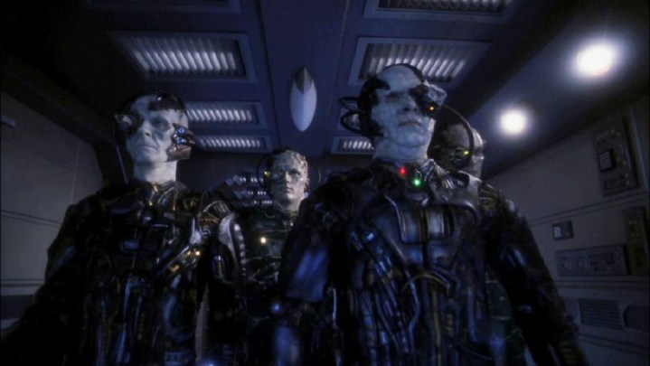 F Borg men stand in a hallway in Star Trek.