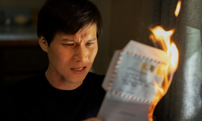 Hoa Xuande holds a burning letter in The Sympathizer.