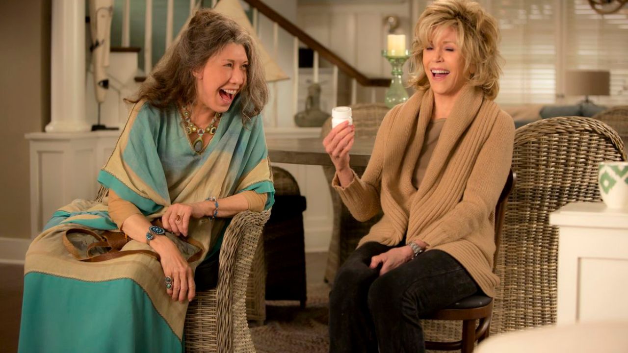 莉莉·汤姆林和简·方达在《格蕾丝和弗兰基》中饰演弗兰基和格蕾丝，他们在沙发上大笑。