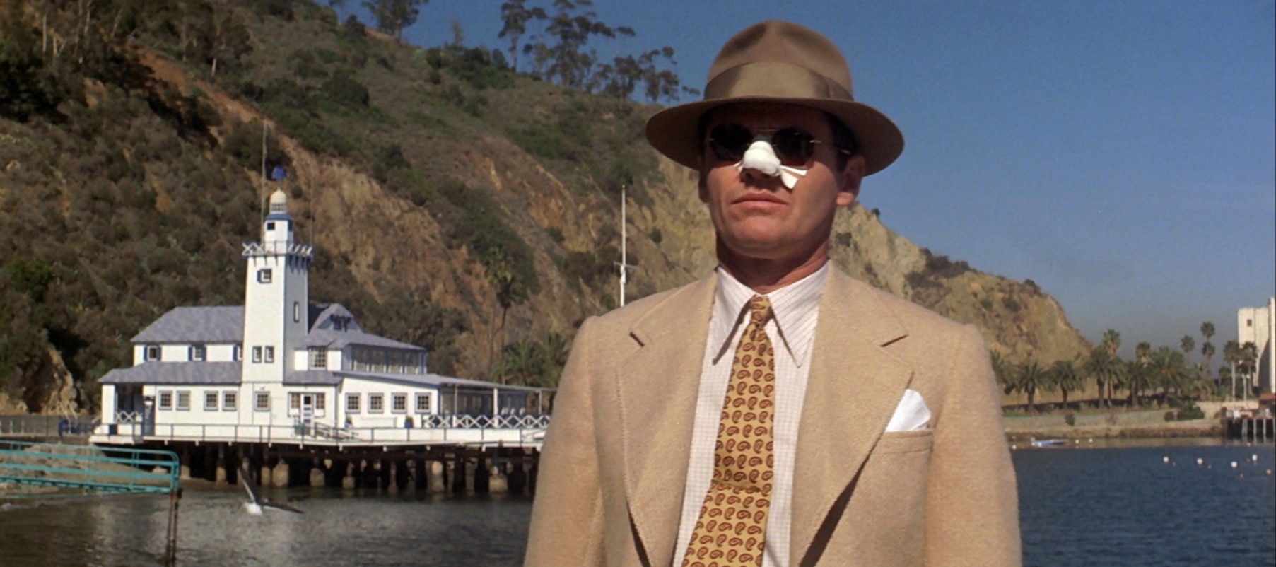 Jack Nicholson standing on a dock in the movie Chinatown (1974)