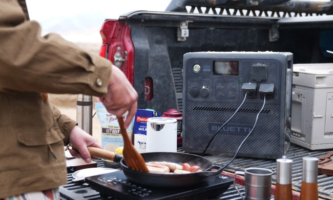 Man using BLUETTI AC240 portable power station while camping to cook