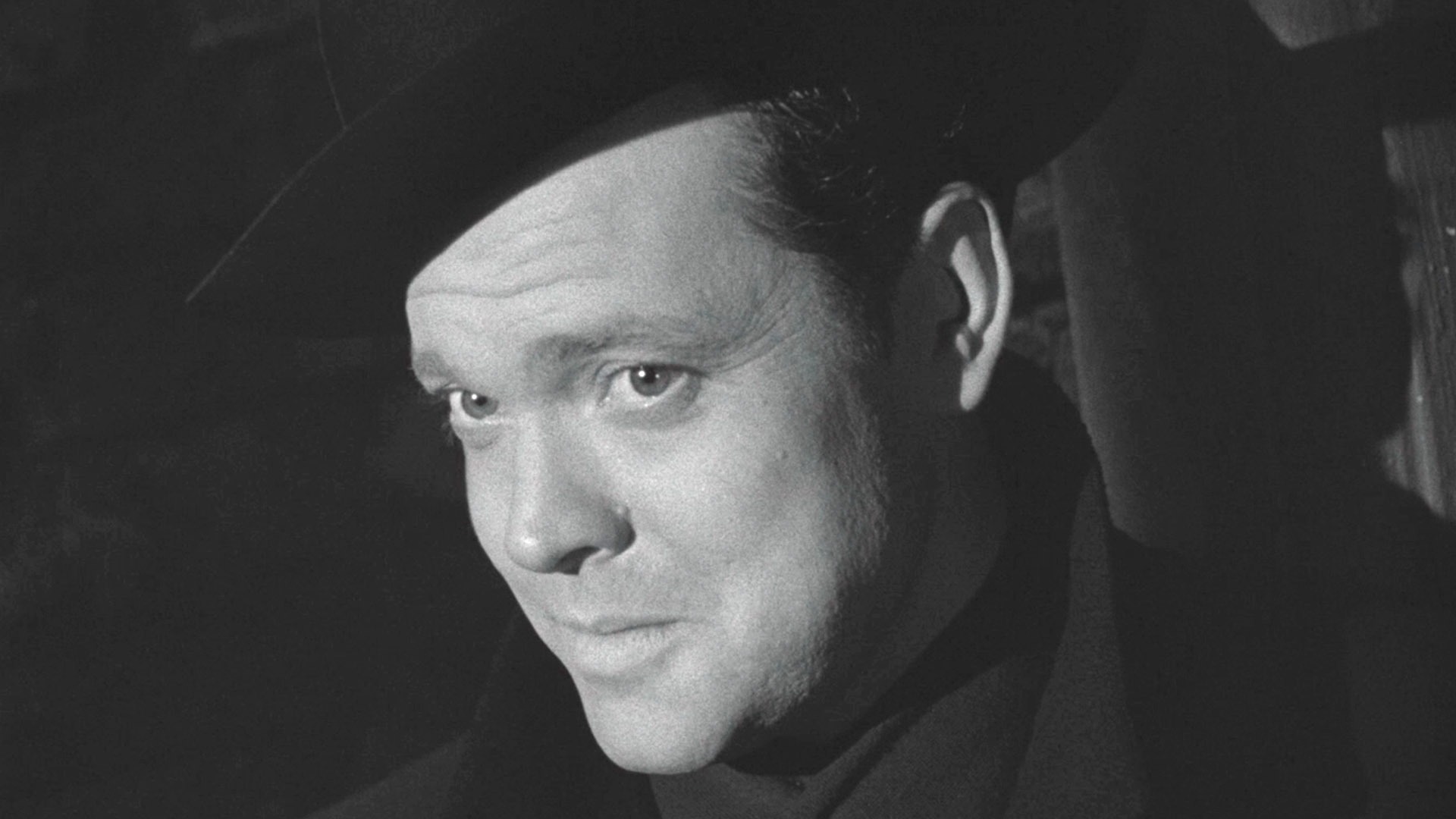 Orson Welles como Harry Lime sonriendo en El tercer hombre.
