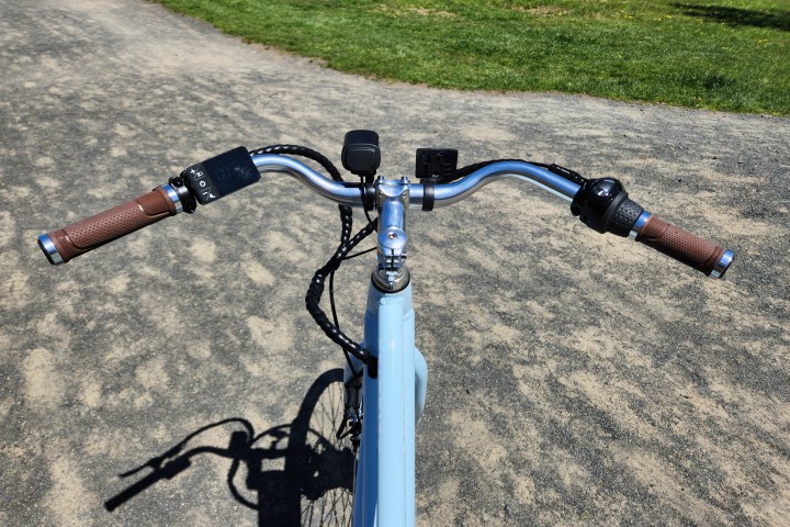 Priority Bicycles e-Classic Plus 电动自行车后掠式车把，左侧有显示屏控制装置，靠近把立的显示屏和前灯，右侧有封闭式 Nexus 变速杆，