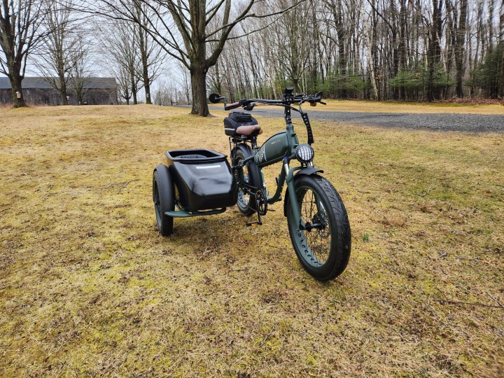Vista di tre quarti anteriore destra di un Sidecar MOD Easy con specchietti opzionali e borsa per portapacchi posteriore in un parco sull'erba,
