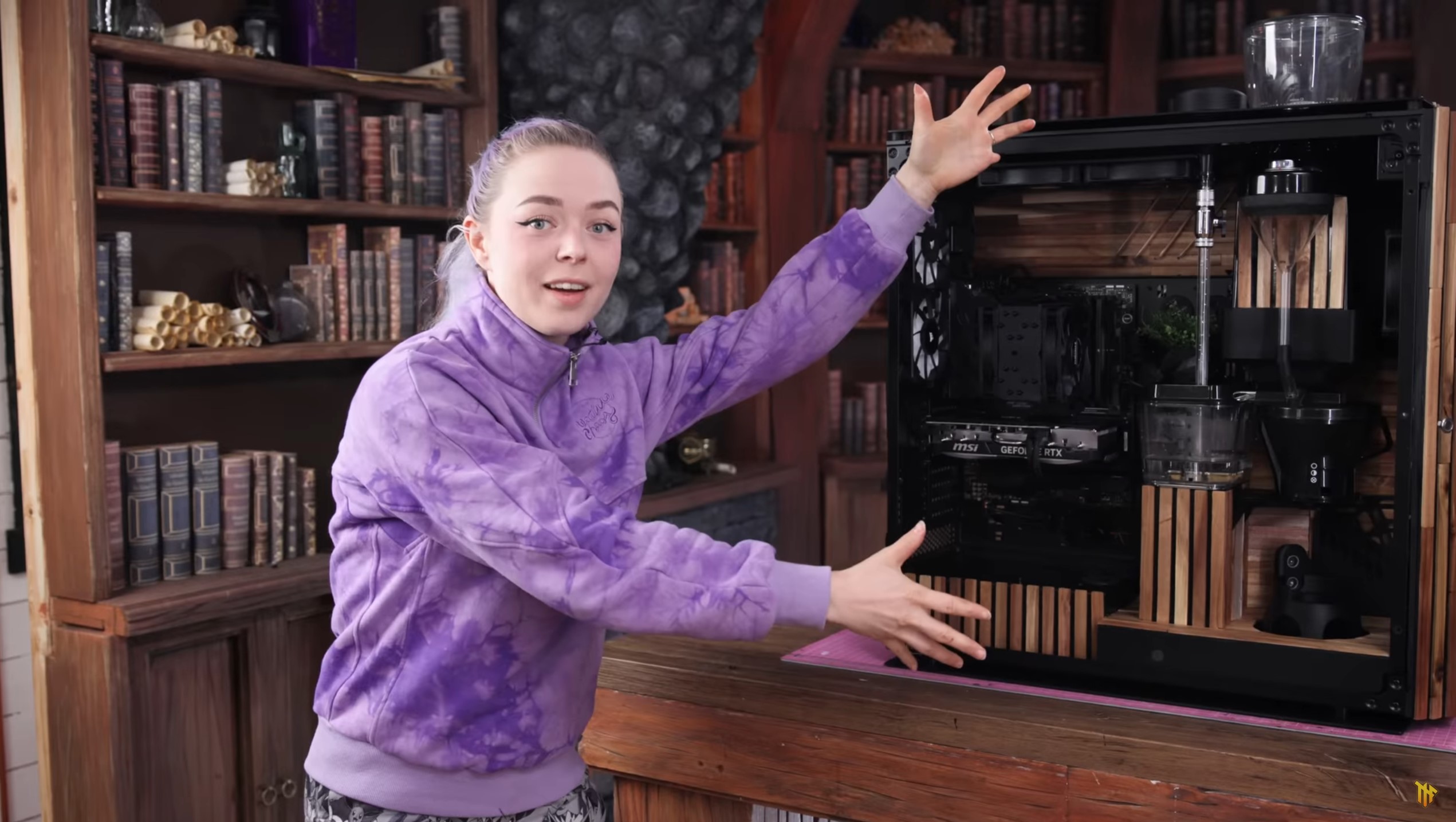 Martina of Nerdforge stands next to a custom gaming PC.