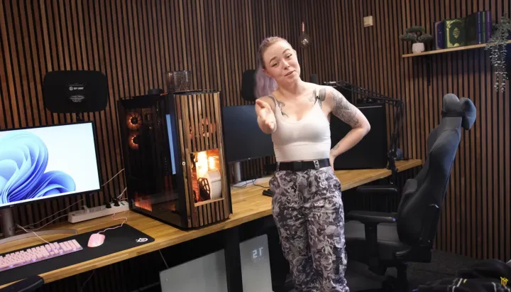 A woman stands next to a custom-built gaming PC with a coffee maker inside.