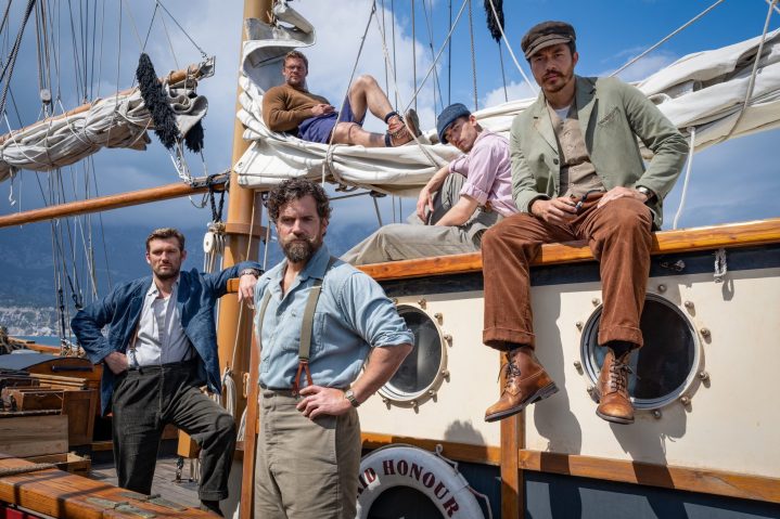 《乱兵部》的演员们坐在船上，站在船上。